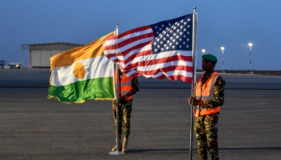Two Nigerien soldiers hold the American and Nigerien flags at Air Base 101 in Niamey in June 2024.