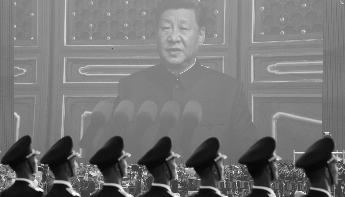 Chinese soldiers in front of a giant screen showing President Xi Jinping.