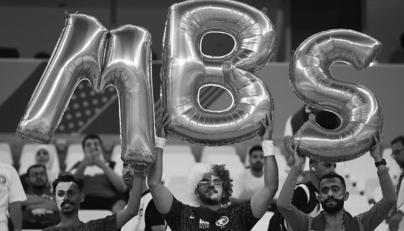 Fans hold up balloons to spell the initials of Saudi Arabia's Crown Prince Mohammed bin Salman on 30 November 2022 during the FIFA World Cup in Qatar. 
