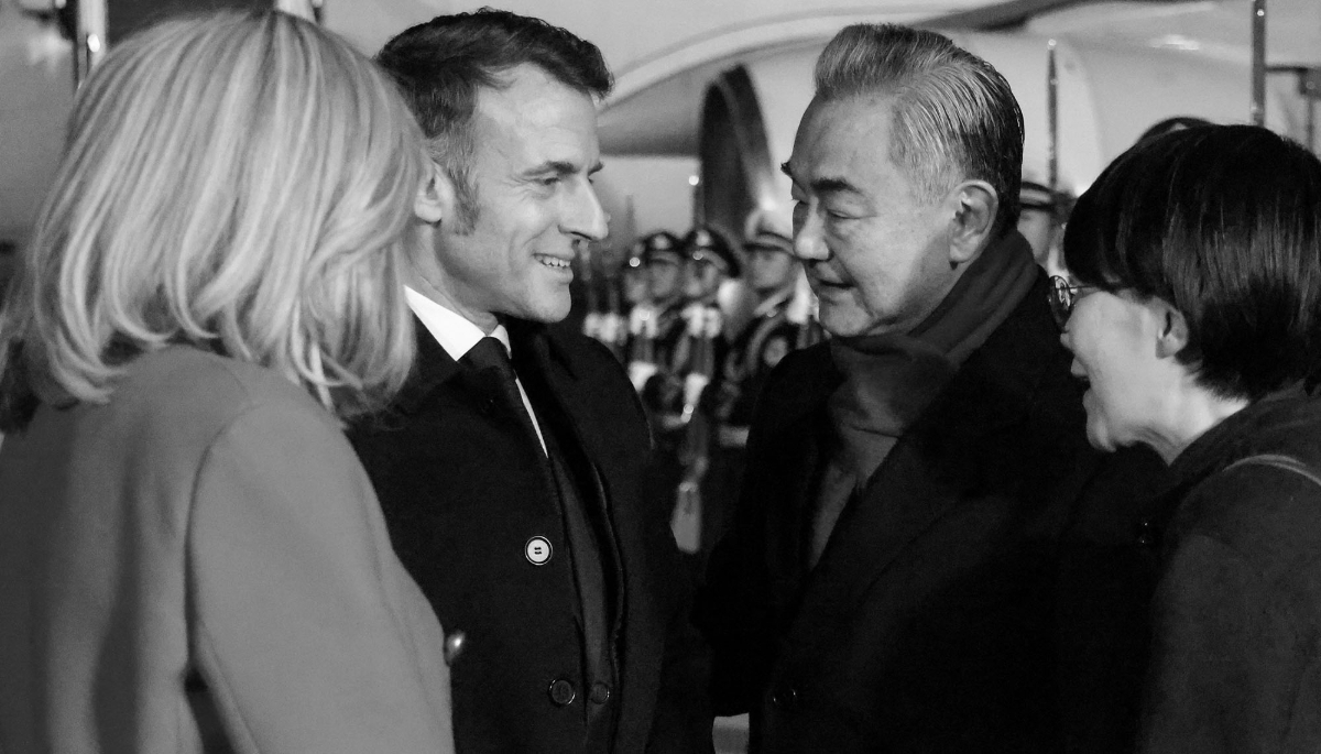Chinese Foreign Minister Wang Yi welcomes French President Emmanuel Macron and his wife Brigitte Macron at Beijing International Airport on 3 December 2025. 