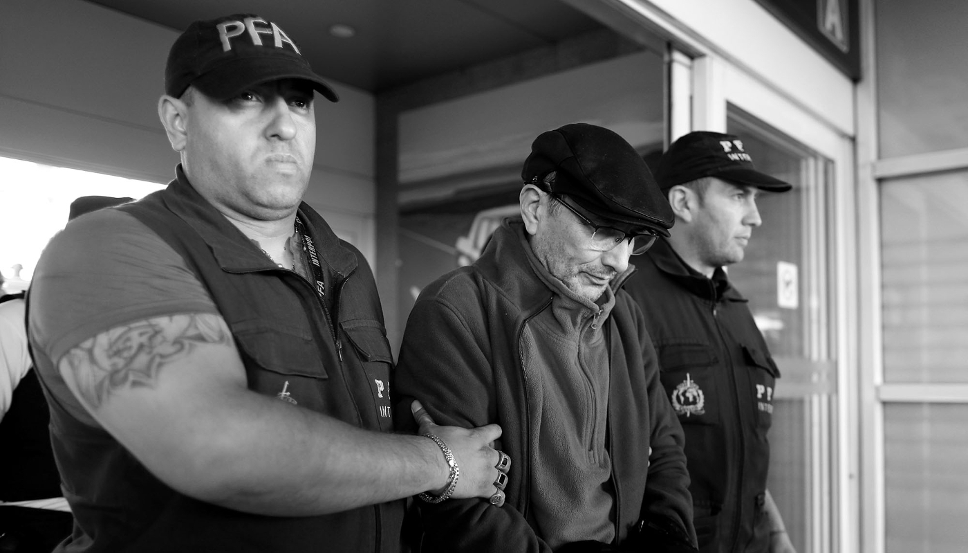 Mario Sandoval, a former Argentine police officer accused of crimes against humanity committed in Argentina, is escorted by police officers at Ministro Pistarini International Airport after being extradited from France, in Buenos Aires, on 16 December 2019.