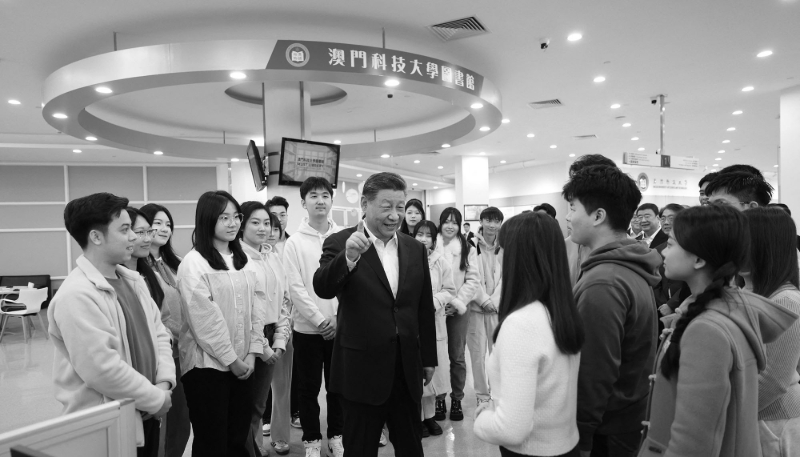 Chinese President Xi Jinping talks with students in the library of Macau University of Science and Technology (MUST) in southern China, on 19 December 2024. 